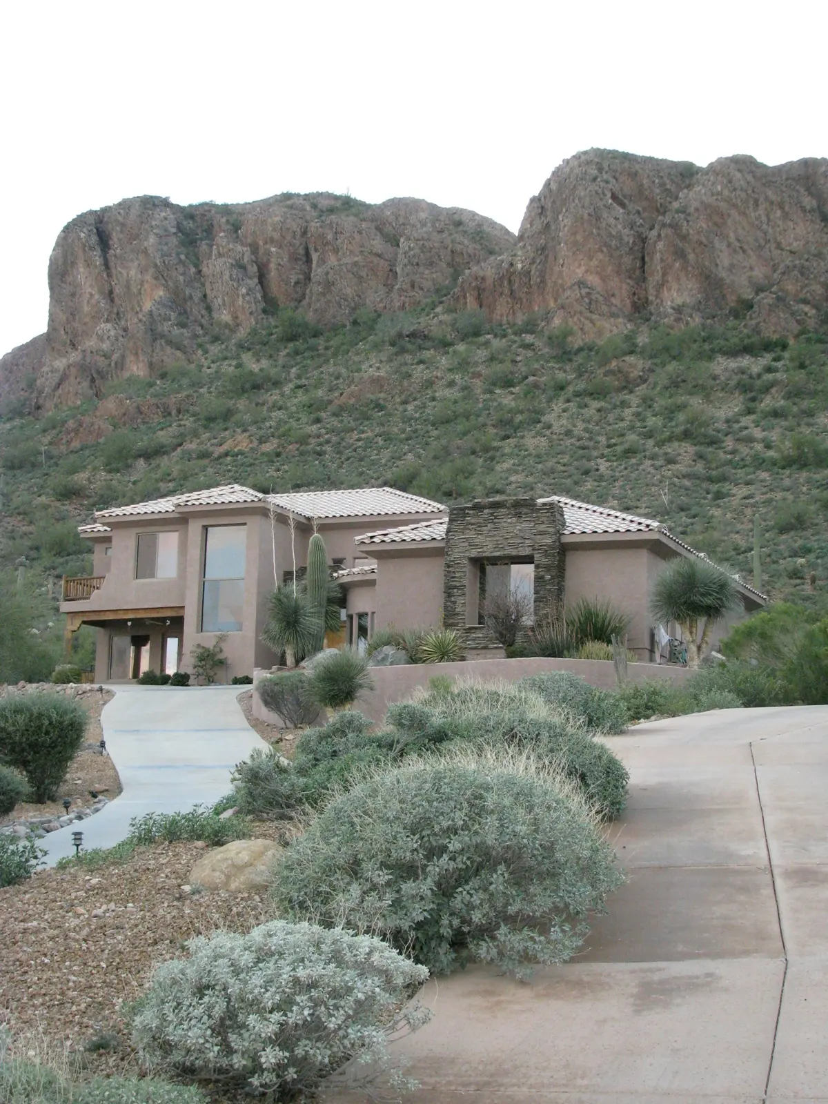 Stucco home below a desert mountain