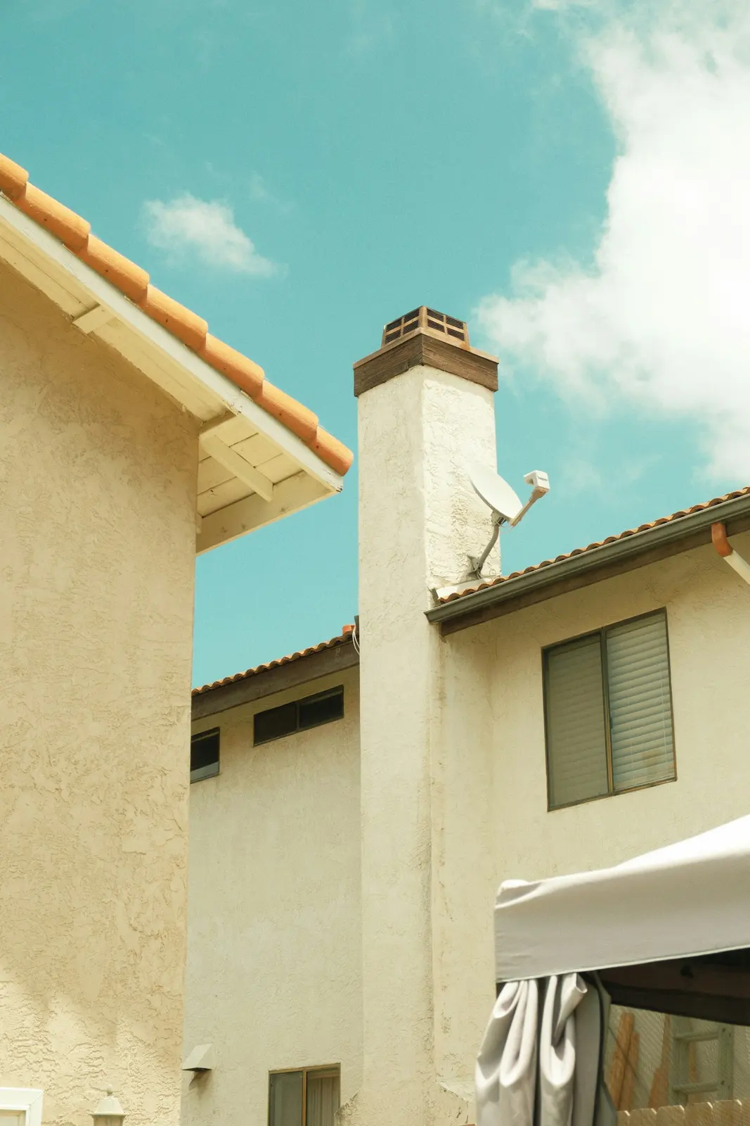 White stucco chimney on a two-story home